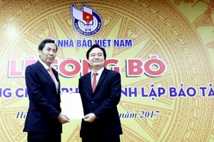 Chủ tịch Hội Nhà báo Việt Nam Thuận Hữu (bên trái) tiếp nhận Quyết định của Thủ tướng Chính phủ về thành lập Bảo tàng Báo chí Việt Nam