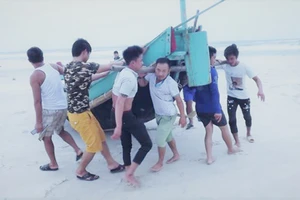 Ngư dân xã Hải Ninh, Quảng Ninh, Quảng Bình đưa thuyền cá lên bờ