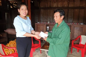 Bà Cao Thị Hoa, Phó Chủ tịch UBND xã Minh Hóa, thay mặt bạn đọc Báo SGGP trao số tiền 10 triệu đồng đến cựu binh Trương Văn Thanh