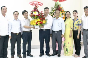 Đồng chí Phạm Gia Túc (thứ 4 từ phải) tặng hoa chúc mừng VPĐD Báo SGGP tại ĐBSCL. Ảnh: HÀM LUÔNG