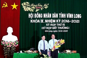 Ông Trần Văn Rón, Bí thư Tỉnh ủy Vĩnh Long (bên trái), tặng hoa chúc mừng ông Lữ Quang Ngời. Ảnh: PHAN THANH