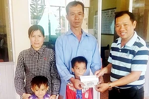Đại diện Báo SGGP (bên phải) trao 16,7 triệu đồng của bạn đọc Báo SGGP hỗ trợ gia đình chị Thu Vân để có điều kiện trị bệnh và đón tết 