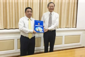 Phó Chủ tịch UBND TPHCM Lê Văn Khoa trao quyết định cho ông Võ Khánh Hưng (phía bên trái).