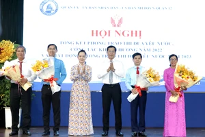 Bí thư Quận ủy quận 12 Trần Hoàng Danh và Phó Giám đốc Sở Nội vụ TPHCM Ngô Thị Hoàng Các tặng hoa chúc mừng các tập thể được nhận cờ thi đua của TPHCM