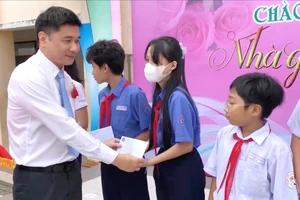 Phó Giám đốc BHXH TPHCM Trần Dũng Hà trao học bổng cho học sinh Trường THCS Nguyễn Văn Luông