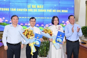 Chủ tịch UBND TPHCM Phan Văn Mãi và Phó Chủ tịch UBND TPHCM Dương Anh Đức trao quyết định, hoa chúc mừng bà Võ Thị Trung Trinh và ông Nguyễn Đức Chung. Ảnh: VIỆT DŨNG