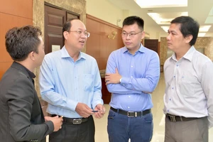 Đồng chí Nguyễn Hồ Hải trao đổi với các đại biểu bên lề hội thảo. Ảnh: CAO THĂNG