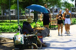 Trong khi nhiều người Hà Nội tránh ra đường trong ngày nắng gắt thì du khách quốc tế không ngại "đội" nắng dạo phố. Ảnh: HÀ NGUYỄN