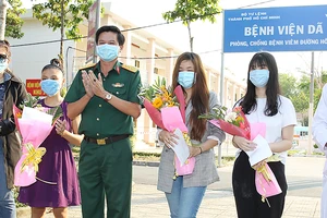 Thượng tá Hà Văn Tiến tặng hoa cho các bệnh nhân xuất viện. Ảnh: HOÀNG HÙNG