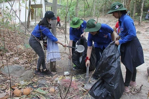 Nhóm bạn trẻ TPHCM dọn rác, làm sạch môi trường tại núi Dinh (Bà Rịa - Vũng Tàu). Ảnh: VÕ THẮM