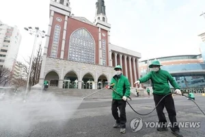 Công nhân khử trùng một khu vực xung quanh nhà thờ Myungsung, một nhà thờ có 80.000 tín đồ, tại Seoul, ngày 26-2, sau khi một mục sư của nhà thờ xét nghiệm dương tính với chủng mới của virus Corona. Ảnh: Yonhap
