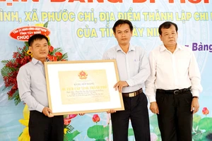 Chủ tịch UBND tỉnh Tây Ninh Phạm Văn Tân (bìa phải) trao bằng công nhận di tích lịch sử chi bộ Đảng đầu tiên của tỉnh