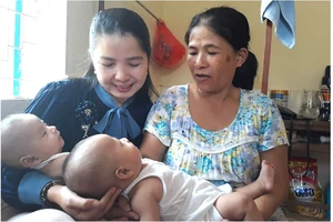 Nụ cười hạnh phúc của Lê Thị Thùy Na (bìa trái) bên cặp song sinh Thanh Bình và Tuấn Tú