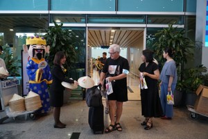 Passengers receive gifts, including traditional conical hats and typical items of Da Nang tourism. (Photo: SGGP)