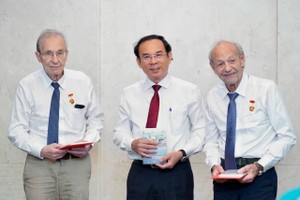 Secretary of the HCMC Party Committee Nguyen Van Nen (C) awards the Ho Chi Minh City Badge to Mr. Olivier Parriaux and Mr. Bernard Bachelard, recognizing their historic contribution. (Photo: SGGP)