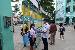 Học sinh Trường Tiểu học An Hội (quận Gò Vấp) được đo thân nhiệt ngay tại cổng trường