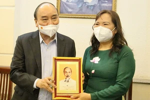 Chủ tịch nước Nguyễn Xuân Phúc thăm, tặng quà Nhà giáo Ưu tú Triệu Thị Huệ. Ảnh: HOÀNG HÙNG