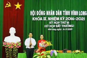 Chủ tịch UBND tỉnh Vĩnh Long (trái) trao hoa chúc mừng tân Phó Chủ tịch