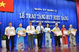 Đồng chí Nguyễn Thị Lệ, Phó Bí thư Thành ủy, Chủ tịch HĐND TPHCM trao huy hiệu Đảng cho các đảng viên tại quận 11. Ảnh: VIỆT DŨNG