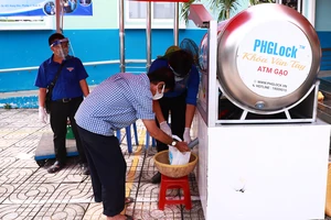 Người dân khó khăn nhận gạo từ máy ATM gạo