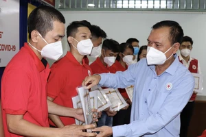 Chủ tịch Hội Chữ thập đỏ TPHCM Trần Trường Sơn trao giấy khen cho tình nguyện viên