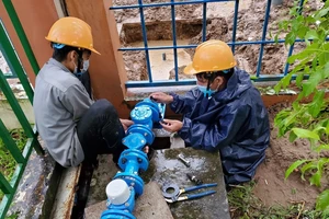 Nhân viên ngành nước lắp đường ống, đầu hồ nước