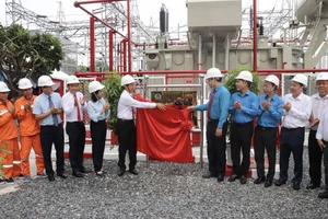 Các đại biểu thực hiện nghi thức gắn biển công trình “Lắp máy biến thế thứ 3 tại trạm 110kV Trường Đua”