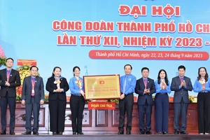 Bí thư Thành ủy TPHCM Nguyễn Văn Nên trao tặng Bảng đồng với dòng chữ Công đoàn TPHCM Đổi mới – Dân chủ – Đoàn kết – Phát triển đến đại hội. Ảnh: VIỆT DŨNG.