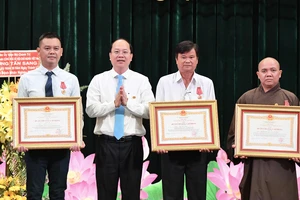 Phó Bí thư Thường trực Thành ủy TPHCM Nguyễn Hồ Hải trao Huân chương Lao động Ba của Chủ tịch nước đến 3 cá nhân. Ảnh: VIỆT DŨNG