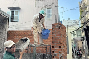Người dân hẻm 76/47 Phan Tây Hồ, phường 7, quận Phú Nhuận thực hiện sửa lại nhà sau hiến đất. Ảnh: VIỆT DŨNG