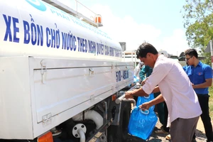 Người dân huyện Tân Phú Đông lấy nước sạch từ xe bồn hỗ trợ nước của SAWACO