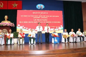 Phó Bí thư Thành ủy TPHCM Nguyễn Phước Lộc chúc mừng các đảng viên nhận Huy hiệu Đảng đợt 19-5 tại quận 12