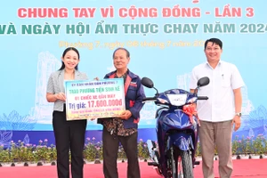 Niềm vui của người dân phường 7, quận Phú Nhuận khi được trao tặng phương tiện sinh kế là chiếc xe máy. Ảnh: VIỆT DŨNG