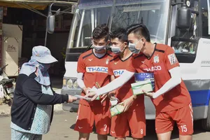 Các cầu thủ HAGL nhiệt tình phát khẩu trang miễn phí cho người dân phố núi. Ảnh: ANH TIẾN