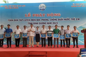 Ông Cao Văn Chóng - PGĐ Sở Văn hóa, Thể thao và Du lịch và bà Nguyễn Thị Kim Nguyên - Phó Chủ tịch UBND thành phố Tân Uyên tặng cờ lưu niệm cho các đơn vị tham dự Lễ Phát động