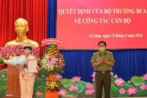 Đại tá Phạm Thành Sỹ trao quyết định của Bộ trưởng Bộ công an cho Thượng tá Đoàn Thanh Thủy. ẢNH: HOÀNG GIANG