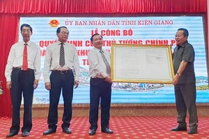 Ông Mai Văn Huỳnh (bên phải), Phó Bí thư Thường trực, Chủ tịch HĐND tỉnh Kiên Giang, thừa uỷ quyền của Thủ tướng Chính phủ trao quyết định thành lập Khu kinh tế cửa khẩu Hà Tiên. Ảnh: KHÁNH THÙY