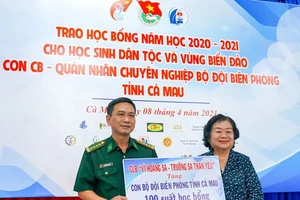 Đại tá Nguyễn Quang Hà, Phó Chính ủy Bộ Chỉ huy Bộ đội Biên phòng tỉnh Cà Mau nhận bảng tượng trưng 100 suất học bổng trị giá 100 triệu đồng do bà Trương Mỹ Hoa trao tặng. Ảnh: BĂNG THANH