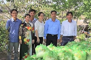 Ông Trần Tấn Nhanh và đại diện địa phương trao quà nhu yếu phẩm cho bà con