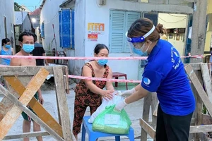 Tình nguyện viên đến trao nhu yếu phẩm từ "Chợ Nghĩa Tình"