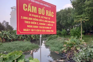 Một con rạch ở phường 15 (quận Gò Vấp) bị người dân quăng rác dày đặc, gây tắc nghẽn dòng chảy và bốc mùi hôi thối, dù có biển cấm đổ rác của UBND phường. Ảnh: Đức Trung