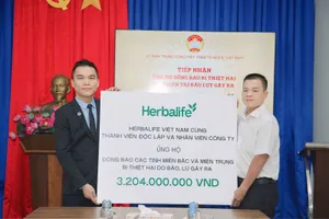 Đại diện Herbalife Việt Nam Ông Nguyễn Thành Đạt, Giám Đốc Truyền Thông (áo west đen) trao tiếp nhận ủng hộ cho Ông Nguyễn Hải Nam