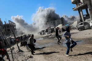 9月8日，加沙城一座高层建筑遭以色列军队空袭后升起浓烟，民众纷纷躲避