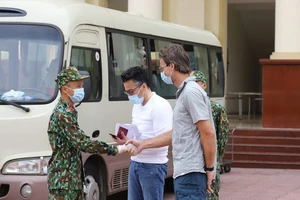 Cán bộ, chiến sĩ tại khu vực cách ly Trường Quân sự, Bộ Tư lệnh Thủ đô chúc mừng khách nước ngoài đã hoàn thành thời gian cách ly khi đến Việt Nam từ vùng dịch. Ảnh: VIẾT CHUNG