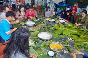 Người dân TP Vinh (Nghệ An) gói bánh chưng chuyển vào ủng hộ đồng bào bị lũ lụt. Ảnh: TRẦN TRUNG HIẾU