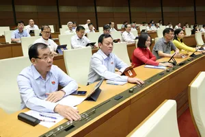 Đại biểu Quốc hội bấm nút biểu quyết thông qua luật, sáng 16-6. Ảnh: QUANG PHÚC