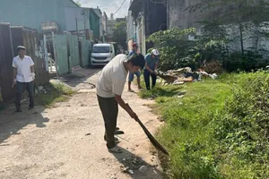 Các cán bộ xã Vĩnh Lộc, TPHCM ra quân dọn vệ sinh trên địa bàn xã. Ảnh: THANH HIỀN