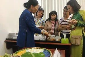 Nghệ nhân Trương Thị Chiều (góc trái) đang giới thiệu các loại bánh tới khách mời trưa 5-3
