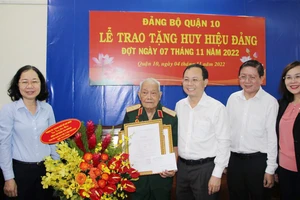 Phó Bí thư Thành ủy Nguyễn Văn Hiếu trao tặng Huy hiệu 75 năm tuổi Đảng cho Thiếu tướng Đoàn Văn Khoan. Ảnh: TRẦN YÊN