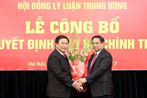 Đồng chí Phạm Minh Chính, Ủy viên Bộ Chính trị, Bí thư Trung ương Đảng, Trưởng ban Tổ chức Trung ương trao Quyết định của Bộ Chính trị và tặng hoa cho đồng chí Nguyễn Xuân Thắng. Ảnh: TTXVN